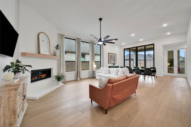 living room featuring ceiling fan and light hardwood / wood-style flooring