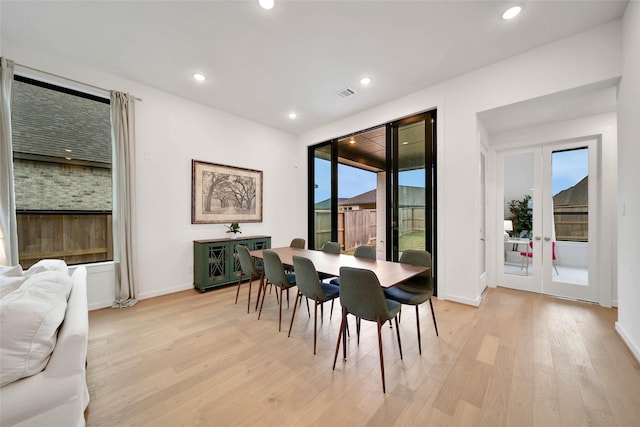 dining room with french doors and light hardwood / wood-style flooring