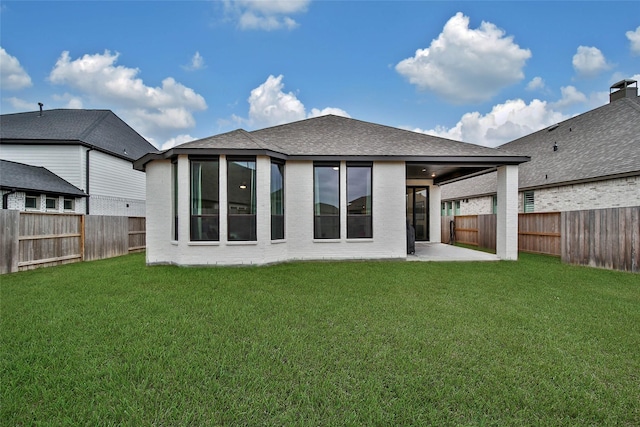 rear view of house featuring a patio area and a yard