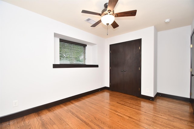 unfurnished bedroom featuring ceiling fan, a closet, and hardwood / wood-style floors