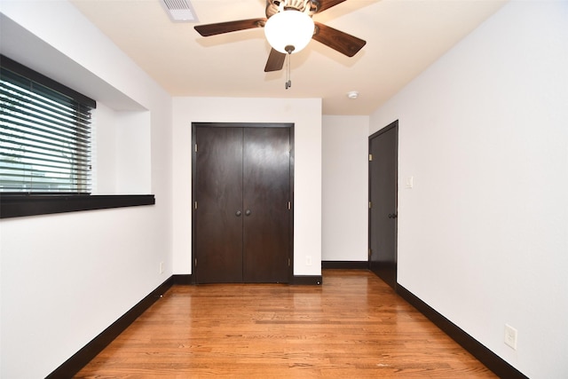 unfurnished bedroom with light wood-type flooring, a closet, and ceiling fan