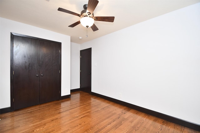 unfurnished bedroom with a closet, hardwood / wood-style flooring, and ceiling fan