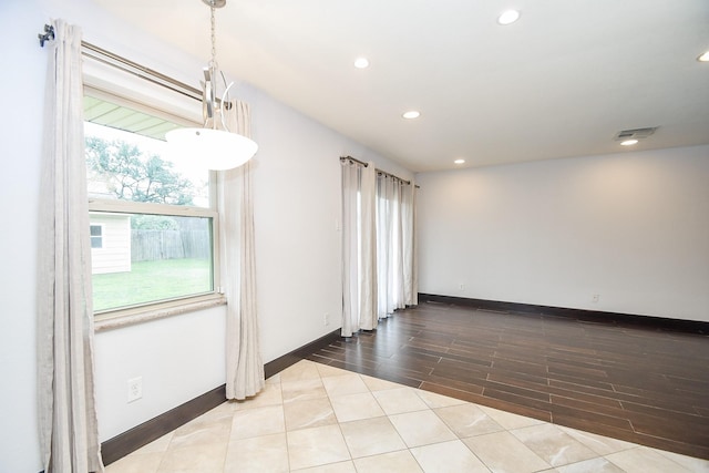 spare room featuring light tile patterned floors and plenty of natural light