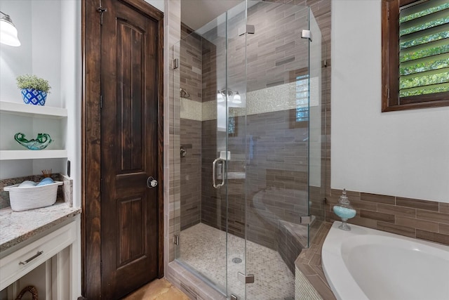 bathroom featuring plus walk in shower and vanity