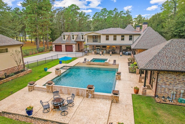 view of pool with a patio area, a lawn, an in ground hot tub, and a fire pit