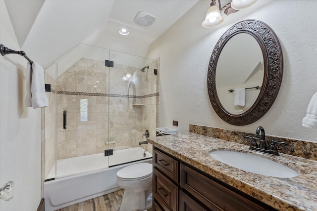 full bathroom with toilet, bath / shower combo with glass door, wood-type flooring, vaulted ceiling, and vanity