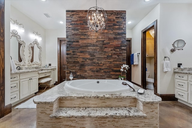 bathroom featuring tiled bath, toilet, vanity, and a notable chandelier