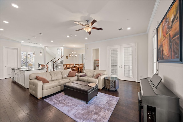 living room with ceiling fan with notable chandelier, sink, dark hardwood / wood-style flooring, ornamental molding, and french doors