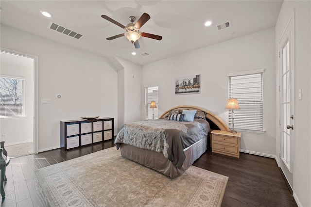 bedroom with ceiling fan, dark hardwood / wood-style flooring, and multiple windows