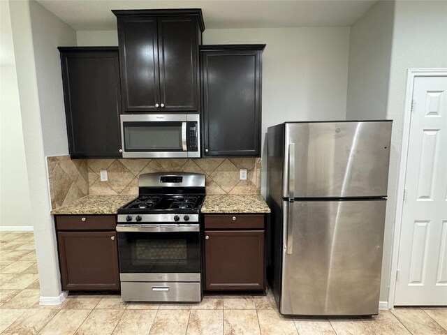 kitchen featuring tasteful backsplash, light tile patterned floors, light stone countertops, and stainless steel appliances