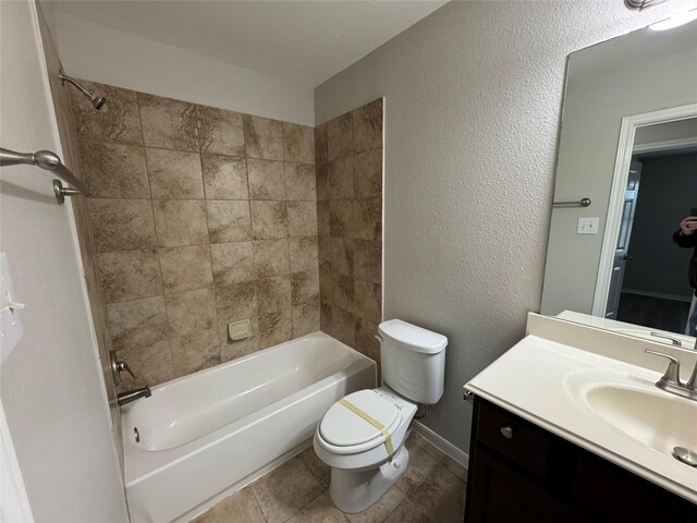 full bathroom featuring toilet, tiled shower / bath, and vanity