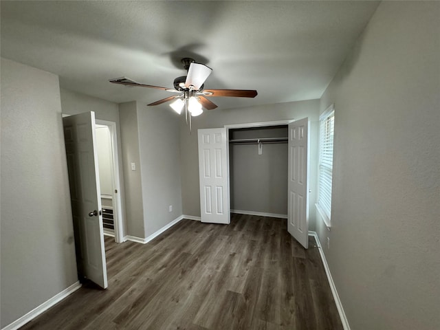 unfurnished bedroom with ceiling fan and dark wood-type flooring