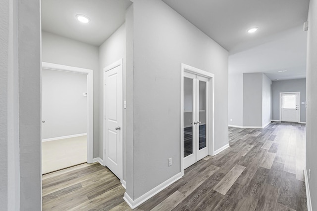 hall with hardwood / wood-style floors and french doors