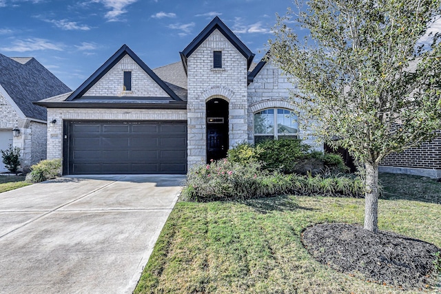 french country home with a front yard and a garage