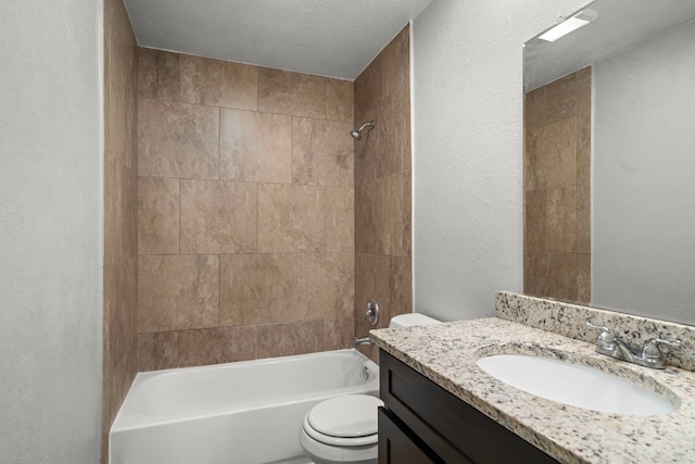 full bathroom with toilet, tiled shower / bath combo, vanity, and a textured ceiling