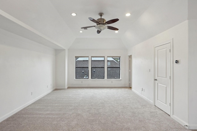 spare room featuring ceiling fan, light carpet, and lofted ceiling