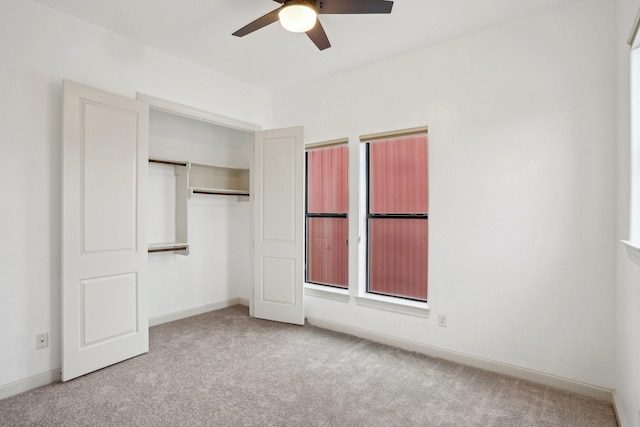 unfurnished bedroom featuring ceiling fan, light colored carpet, and a closet