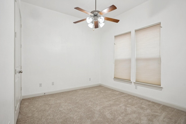 spare room with ceiling fan and light carpet