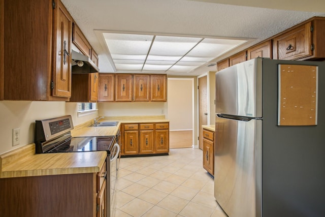 kitchen with sink, light tile patterned flooring, exhaust hood, and stainless steel appliances