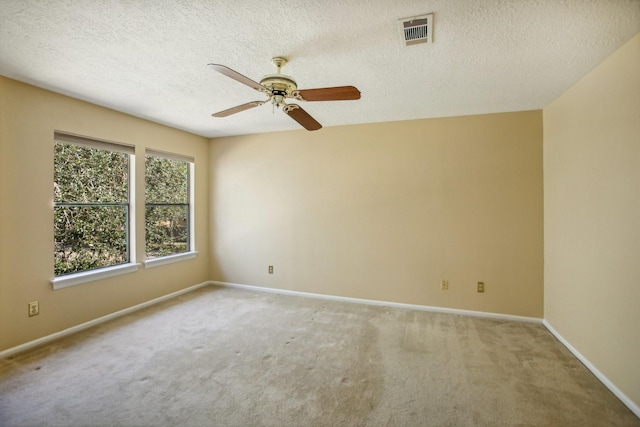 carpeted empty room featuring ceiling fan and a textured ceiling