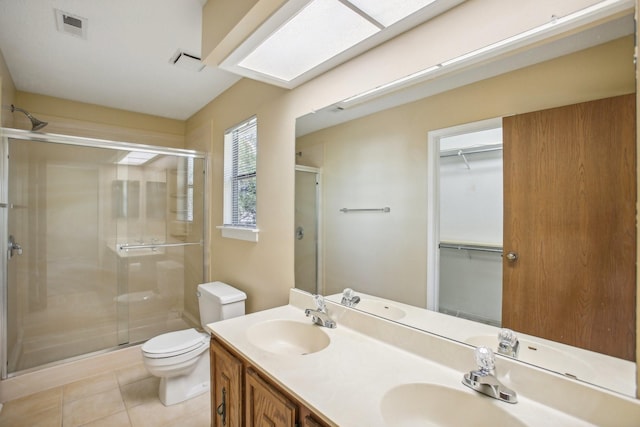 bathroom featuring tile patterned floors, toilet, vanity, and an enclosed shower