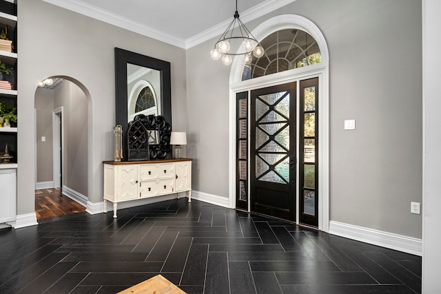 foyer featuring dark parquet flooring, crown molding, and a chandelier