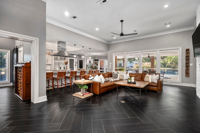 living room with ceiling fan, ornamental molding, and dark parquet floors