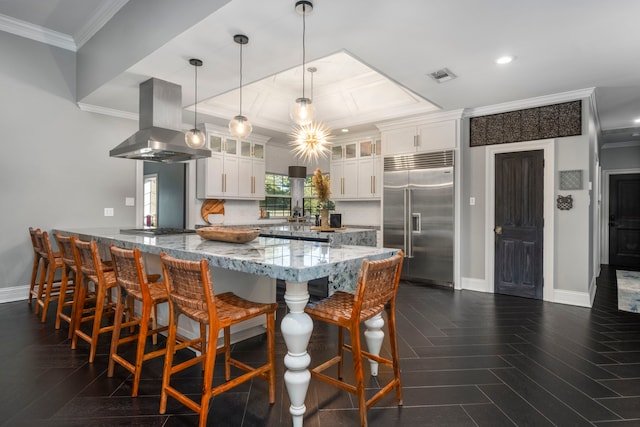 kitchen featuring island range hood, a breakfast bar area, stainless steel appliances, hanging light fixtures, and white cabinets