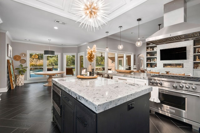 kitchen featuring decorative light fixtures, a center island, island range hood, and high end stove