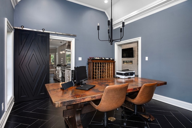 dining space with a high ceiling, crown molding, and a barn door