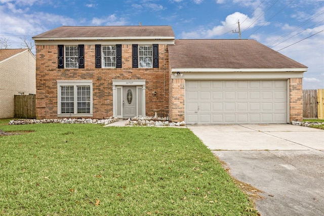 colonial-style house featuring a front yard and a garage