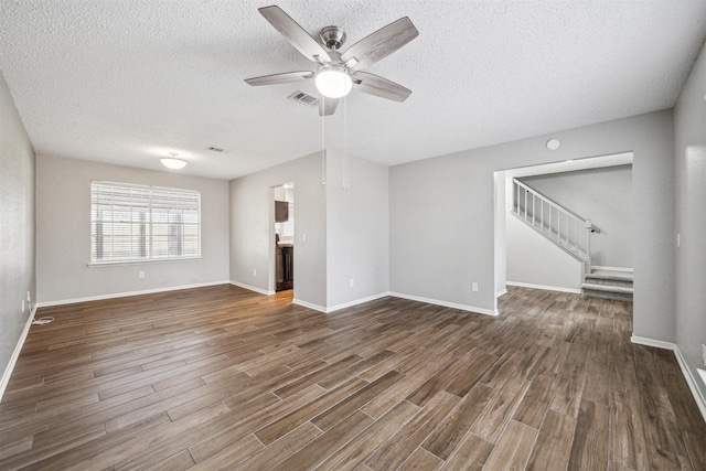 unfurnished living room featuring ceiling fan, dark hardwood / wood-style flooring, and a textured ceiling