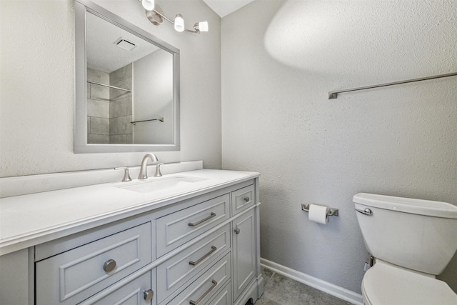 bathroom with toilet, walk in shower, and vanity