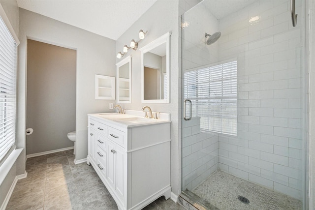 bathroom with toilet, vanity, and walk in shower