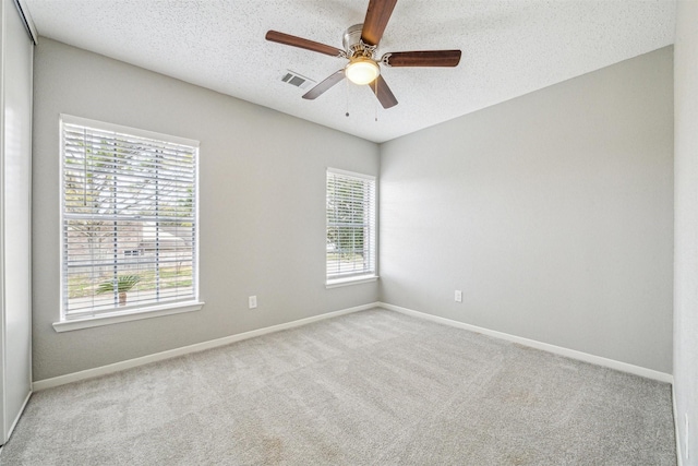 carpeted spare room with ceiling fan and a textured ceiling