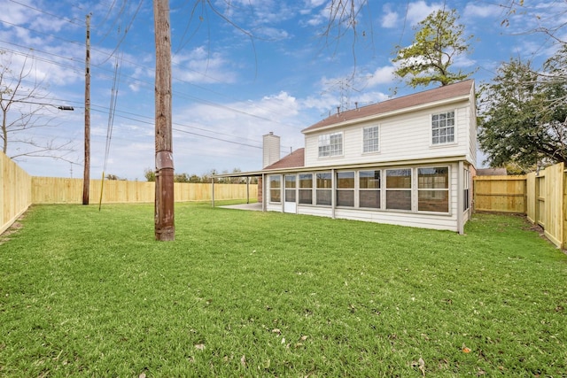 back of property featuring a sunroom and a yard