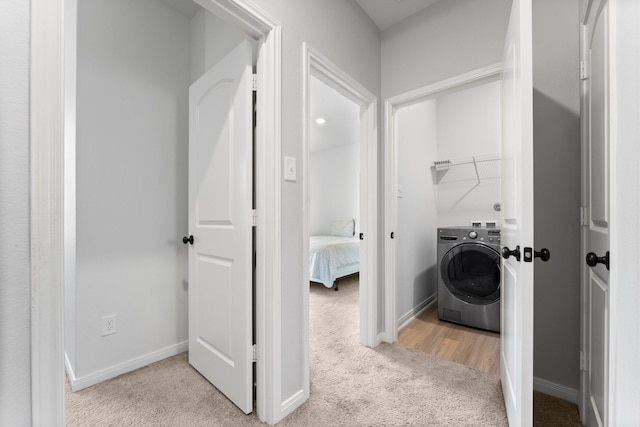 laundry room featuring light colored carpet and washer / dryer