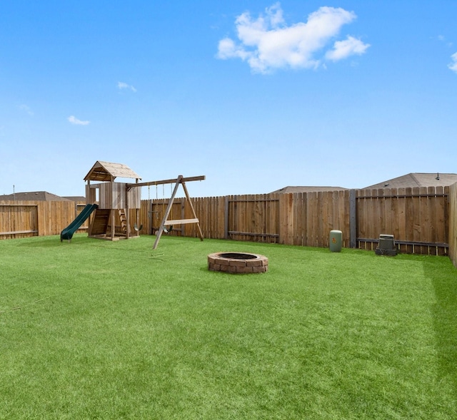 view of yard featuring a playground and an outdoor fire pit