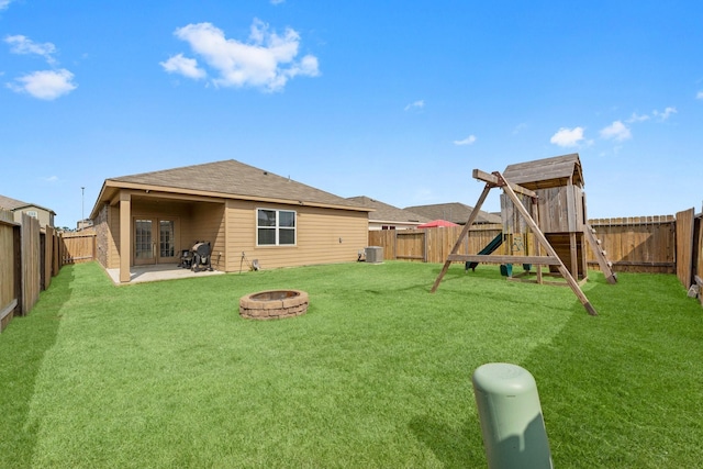 view of yard featuring an outdoor fire pit, central AC, a patio area, and a playground