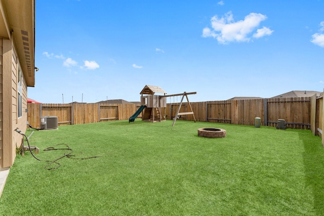 view of yard with a playground, an outdoor fire pit, and cooling unit