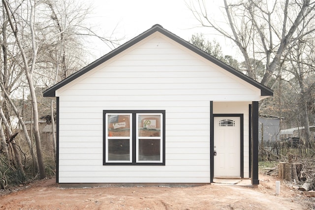 rear view of property featuring an outbuilding