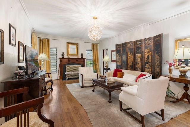 living room with wood-type flooring, crown molding, and an inviting chandelier