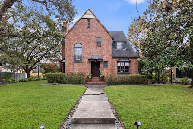 tudor-style house featuring a front yard