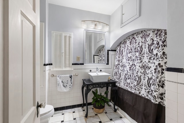 bathroom featuring sink, tile walls, toilet, and tile patterned flooring