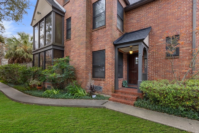 doorway to property featuring a lawn