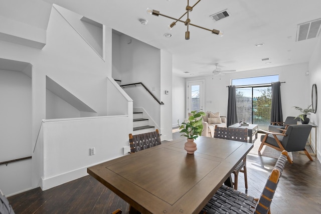 dining area featuring ceiling fan with notable chandelier and dark hardwood / wood-style flooring