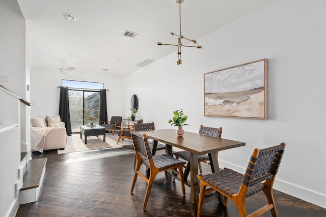 dining room with vaulted ceiling, ceiling fan with notable chandelier, and dark hardwood / wood-style floors