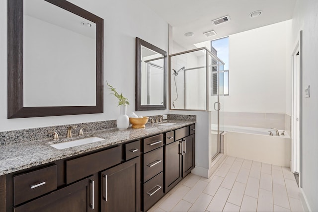 bathroom with vanity and shower with separate bathtub