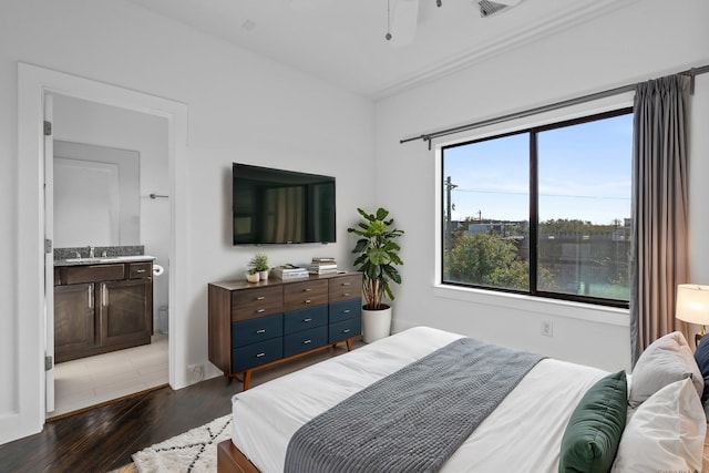 bedroom with dark wood-type flooring, connected bathroom, and sink