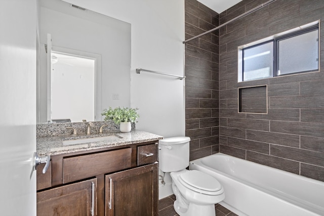 full bathroom with toilet, vanity, and tiled shower / bath combo